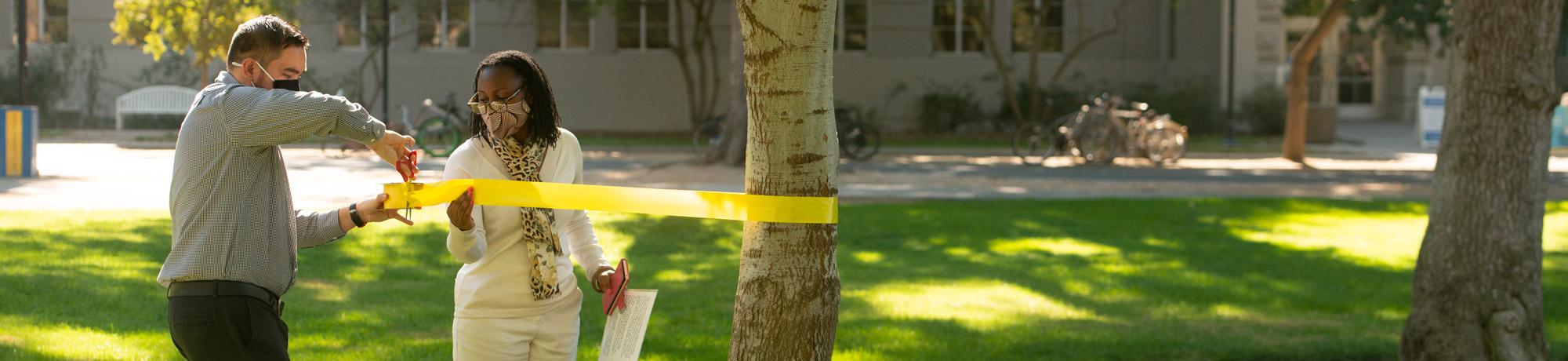 VSC staff tying yellow ribbons around trees on campus